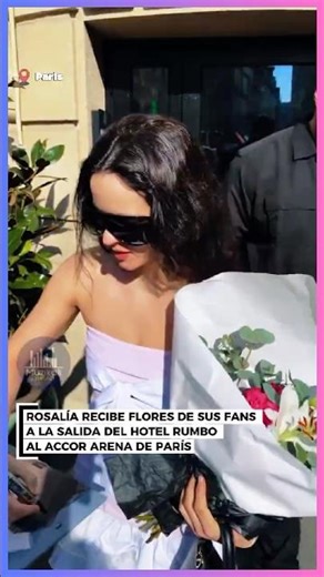 Rosalía receives flowers from her fans as she leaves the hotel.