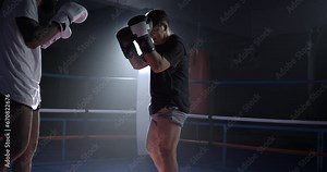 Two fighters facing each other inside boxing ring in dramatic slow-motion at 800 fps with backlight