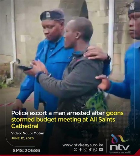 Police escort a man arrested after goons stormed budget meeting at All Saints Cathedral