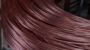 In the process of copper wire manufacturing on the production line of a metallurgical company, a copper smelting plant. Close-up of part of a large spool on which copper wire is wound or coiled.