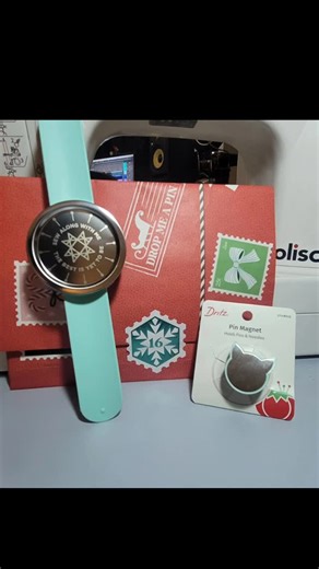 AD on Instagram: "Day 16 - MSQ Jenny Christmas Box 🎄✨ Today’s box is all about keeping things close at hand! 🧵💛 A silicone slap bracelet with a magnetic needle minder (genius for sewing sessions!) plus a cat-shaped magnetic pin holder to keep pins and needles from wandering off. Practical, fun, and totally sewist-approved—because chasing needles is not the vibe. 😅 Would you wear a needle minder while you sew? #MSQChristmasBox #Day16 #NeedleMinder #PinMagnet #SewingNotions QuiltyGoodness Sewi