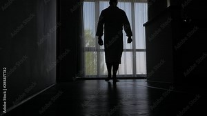 A man in a Bathrobe comes to a large window in the hotel room, a view of the amazing landscape.
