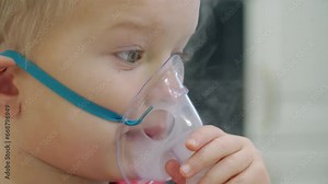 Sick toddler child doing inhalation at home, little boy using nebulizer