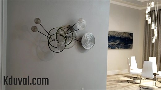 Three axis, interactive kinetic wall sculpture in the entrance to a modern sitting area. Steel, Stainless Steel #kineticart #wallart #metalart #interactiveart #modernart #contemporaryart #interiordesign #mezmerizing #hypnotic #artinmotion