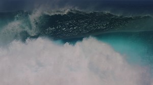 Tracking pan follows crashing dangerous ocean wave erupting with mist and whitewash in slow motion Premium Stock Video Footage