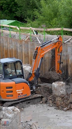 Hitachi ZX65USB Minibagger entfernt Boden zwischen Bohrpfählen