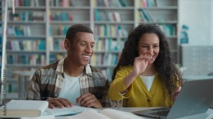 African American man Arab Caucasian woman smile high five together teamwork friends students classmates finish joint project library laptop desktop task done computer university college cooperation Stock Video