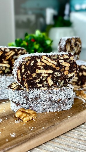 SALAM DE BISCUIȚI Rețeta de salam de biscuiți cu ciocolată este minunată, delicioasă și perfectă pentru momentele în care ne dorim un desert fără coacere. O bunătate ușor de făcut, cu un gust minunat. Haideți să pregătim rețeta! 📋 Ingrediente: • 200 g biscuiți (eu am folosit biscuiți Leibniz) • 100 g nuci • 125 g ciocolată (am folosit Nestlé) • 100 g zahăr • 50 g unt • 100 ml lapte • 20 g cacao • esență de rom • În plus: folie alimentară pentru a forma salamul de biscuiți. 📌 Mod de preparare: 