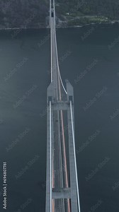 Hardanger Suspension Bridge across the Eidfjorden in Norway in Summer Day. Fjord and Mountains. Aerial View. Drone is Flying Forward, Camera is Tilting Up. Reveal Shot. Vertical Video