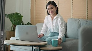 Young beautiful woman is working with her computer at home.