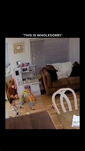 Social dorm on Instagram: "The video features Ring camera footage of a toddler in pajamas sprinting energetically through a cluttered living room and kitchen, sending chairs and toys tumbling along the way. His dad, wearing an orange sweater, follows closely behind, laughing and encouraging him with excited cheers like, “Whoa, look at you go!” “Look at you go, buddy!” “Go, go, go!” and “Come on, big guy!” The clip ends sweetly as the toddler reaches the other side and the dad scoops him into a c