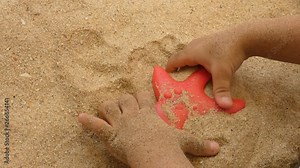 Baby hands playing with sand in the beach
