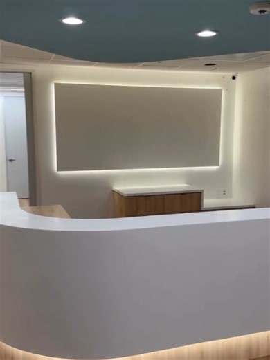 Soft whimsical curves of this reception station is situated perfectly within this modern office. Inviting yet functional—custom reception, and millwork throughout by NK Cabinets. #modernoffice #customreceptiondesk #nkcabinets #losangeles #cabinetmaker