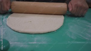 Pizza Dough Preparation using a rolling pin to prepare pizza dough with skill and precision