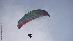 paraglider flying over mountains, summer day, healthy active lifestyle, paragliding