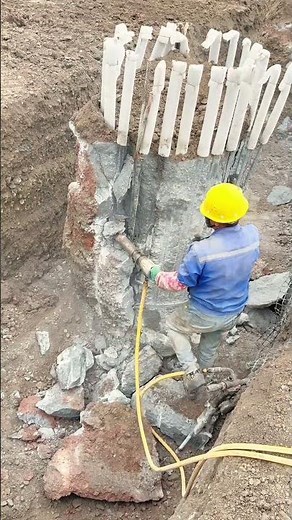 Construction Worker Jackhammering a Concrete Pile Foundation