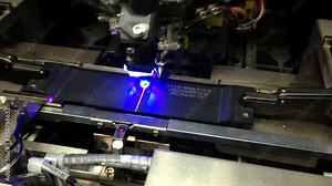 Industrial equipment for testing the quality of the assembly of microchip and electronic circuit board. Shot in motion, Camera Sensor for Mobile Phone Camera. Close up of the production of the sensors