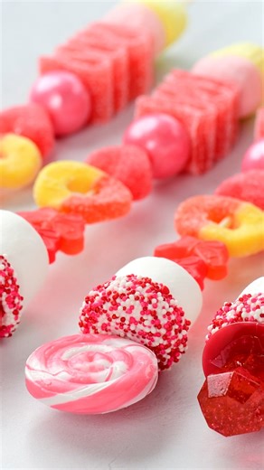 Sweet, colorful Candy Sticks are an adorable treat. Make candy kabobs with lollipops, marshmallows, and gummy candies for Valentine’s Day! #candysticks #kabobs #valentinecandy | The Gunny Sack
