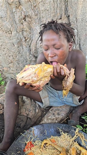 Hadzabe kid enjoying eating big bird meat
