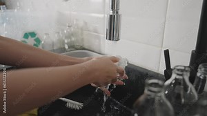 Net Zero waste go green eco people save the planet earth wash rinse clean empty reuse glass bottles sort before recycle bin on touchless sensor faucet tap sink smart home. World water day plastic free