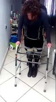A Paraplegic Woman Is Practicing To Walk Using Walker.