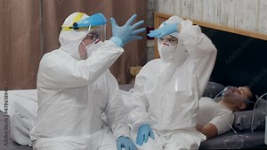 Doctors give resuscitation to a male patient lying with oxygen inhalation mask at home. Successful patient rescue using Oxygen Concentrator. Covid-19 pandemic concept 4K