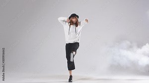 Flexible young dancer doing split leap in the air, raising leg intensively up, standing on one leg, enjoying dancing, athletic modern style dance