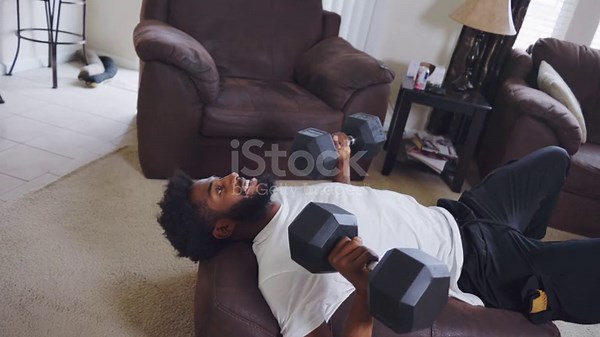 Giovane uomo afroamericano sui vent'anni che fa distensioni su panca...