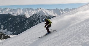Cinematic downhill skiing in beautiful winter mountain landscape with high speed and fresh snow. Sporty skiing with high speed on a steep ski slope in the tyrolean mountains with great light 4K.