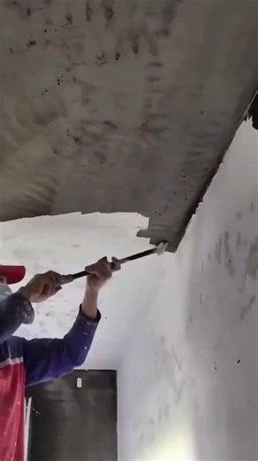 removing a broken plaster ceiling with a long metal tool for a professional home renovation project
