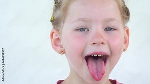 Little girl plays with tongue and saliva. Close-up of a girl face smile. child shows throat and palate to the doctor. Health concept. Play and stick out your tongue and teeth. Salivation in children.