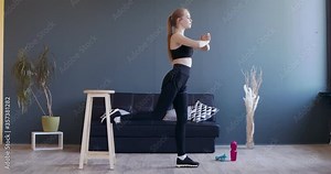 Young girl squatting, keeping one leg on chair behind her