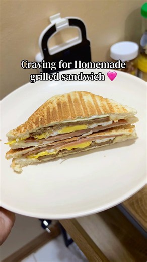 Homemade grilled sandwich for breakfast 🥪🤎 Ham, egg, burger patty, and cheese, crispy on the outside, savory and filling inside! 😋 Dapat may lettuce & cucumber din for that fresh crunch, kaso ubusan na ako. 😂 So today, we make do with what we have. Still sooo good! ✨☕️ #fyp #sandwich #yummy