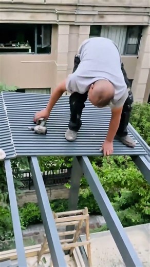 installing aluminum roof panels on a metal pergola frame using a power drill and hammer outdoors