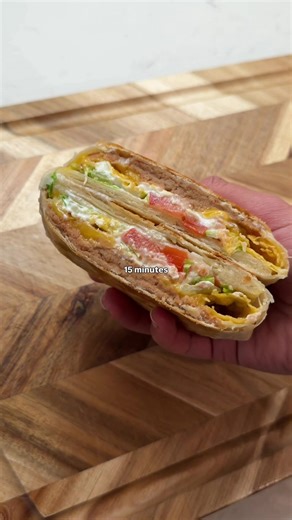 CRUNCHWRAP FOR DINNER (TAKES 15 MINUTES) Grab a large tortilla and spread it with refried beans, then sprinkle on some cheese. Add tortilla chips, layer with sour cream, lettuce, and tomato, and top with a small tortilla. (Use a cup to trace and cut small circles on a large tortilla.) Fold the edges to seal, then cook for 3 minutes per side, until golden and crispy. Serve hot and enjoy! #tacobellathome #crunchwrap #vegetarianmeals