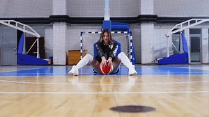 full shot of a cheerleader sitting on the floor with a ball, sport concept. High quality 4k footage