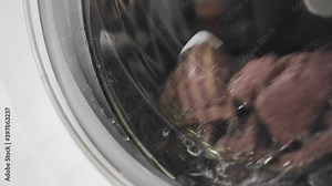 Washing clothes in the washing machine is taken in close-up. Slow motion images