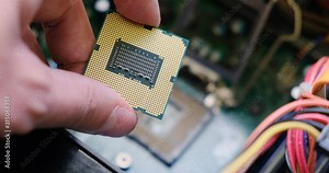 Examining a computer CPU up close above a motherboard. PC custom build.