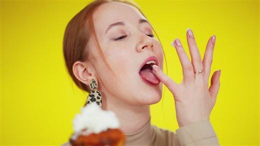 Woman licking frosting off of her fingers from a cupcake - Free Stock Video