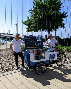 Join us in welcoming Oakville Public Library's first Library ON THE GO Book Bike here in Bronte: featuring reading material for all ages - free to borrow or take home! Grab a book, have a seat at our blue bistro tables, and connect with friends, neighbours, and nature under the sails at Bronte Heritage Waterfront Park. Available weekdays, weather permitting. We can’t wait to see you there! 📚☀️ | Bronte Village BIA Oakville