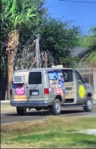 Gray ice cream truck driving on a Saturday
