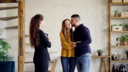 Real estate buyers are getting keys from cheerful housing agent after...