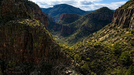 Dramatic canyon view with layered cliffs and natural vegetation