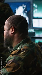 Vertical video Soldier doing tasks in military base, using radar, intercepting and destroying ballistic rockets. Man monitoring army HQ CCTV for any unauthorized activity, tracking missiles, camera A