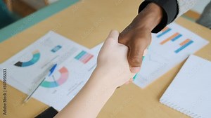 African black man shake hands with his business partner caucasian woman. Handshake when got agreement, deal or signed contract. Diverse business people of different ethnicity and gender. Close-up