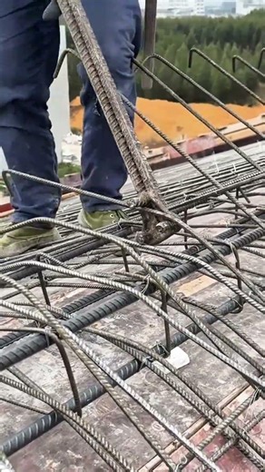 installing and securing structural steel reinforcements for building foundation on construction site