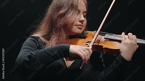 woman violin player is playing fiddle in music hall, young female violinist in opera house