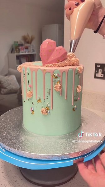 Decorate a drip cake with me 💗🍰 This was such a fun cake to decorate, topped with cake hearts, donuts and cakesicles! I ALWAYS use candy melts for my drips. Melt them in the microwave on 30 second bursts, then add a tablespoon of vegetable oil until you reach the perfect drip consistency. Then add your chosen colour, for this cake I used the shade baby pink from Colour Mill ✨ #dripcaketutorial #dripcakes #dripcakesoftiktok #dripcake #decorateacakewithme #decorateacake #cakedecorating #cakes #c