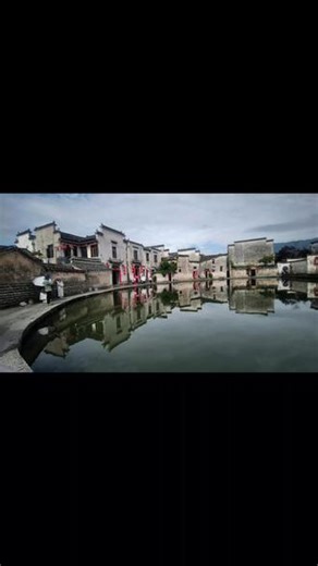 青山环古村，碧水绕街巷。一汪月沼静卧村中，白墙黛瓦尽数倒映清波，水影屋影相融，宛若天然水墨画卷。