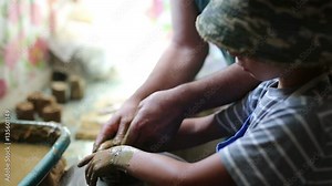 Senior potter teaching happy little boy the art of pottery. Child working with clay, creating modeling ceramic pot on sculpting wheel. Mentoring, generations concept. Pottery lessons workshop for kids Stock Video
